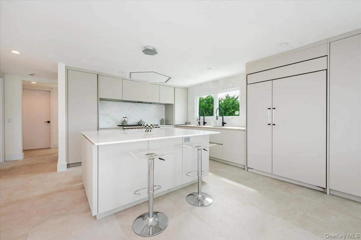 Kitchen featuring backsplash, paneled fridge, decorative light fixtures, a kitchen island, and recessed lighting Kitchen featuring backsplash, paneled fridge, decorative light fixtures, a kitchen island, and recessed lighting