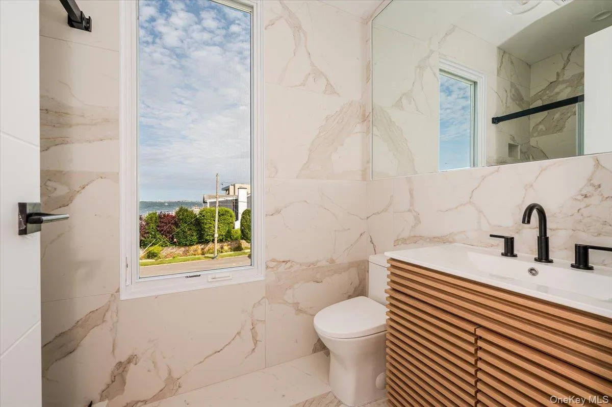 Full bath with vanity, a marble finish shower, and tile walls Full bath with vanity, a marble finish shower, and tile walls