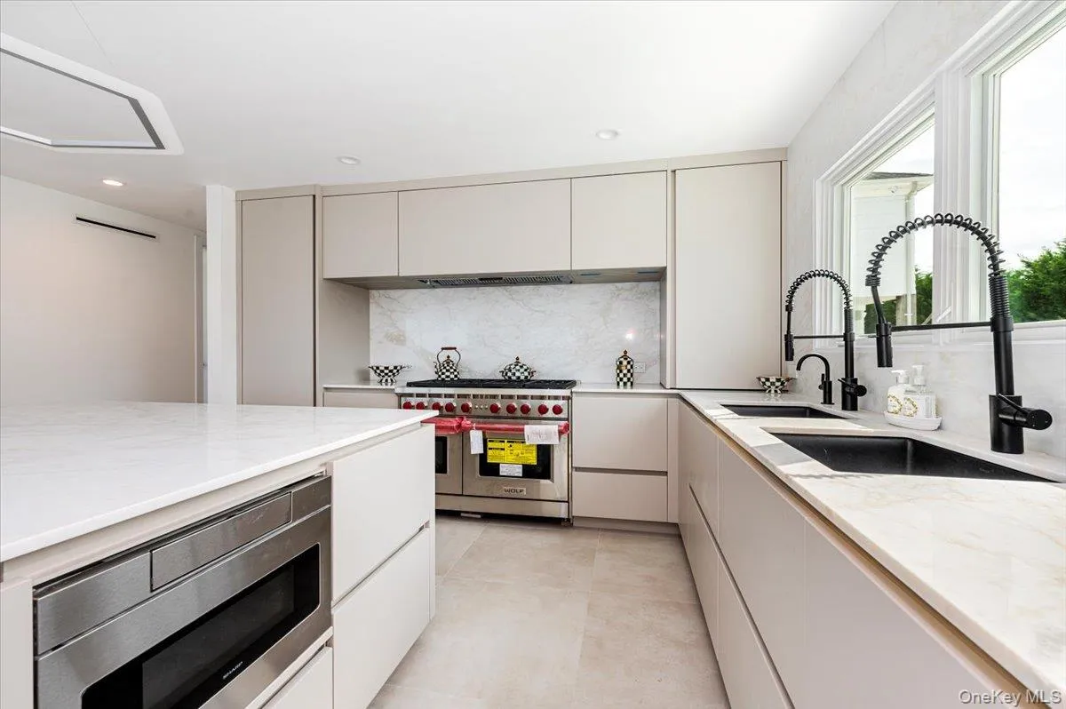 Kitchen featuring backsplash, appliances with stainless steel finishes, light stone countertops, modern cabinets, and recessed lighting Kitchen featuring backsplash, appliances with stainless steel finishes, light stone countertops, modern cabinets, and recessed lighting