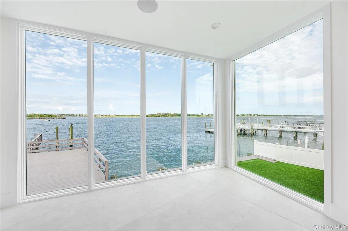 Unfurnished sunroom with a water view, floor to ceiling windows, and tile patterned floors Unfurnished sunroom with a water view, floor to ceiling windows, and tile patterned floors