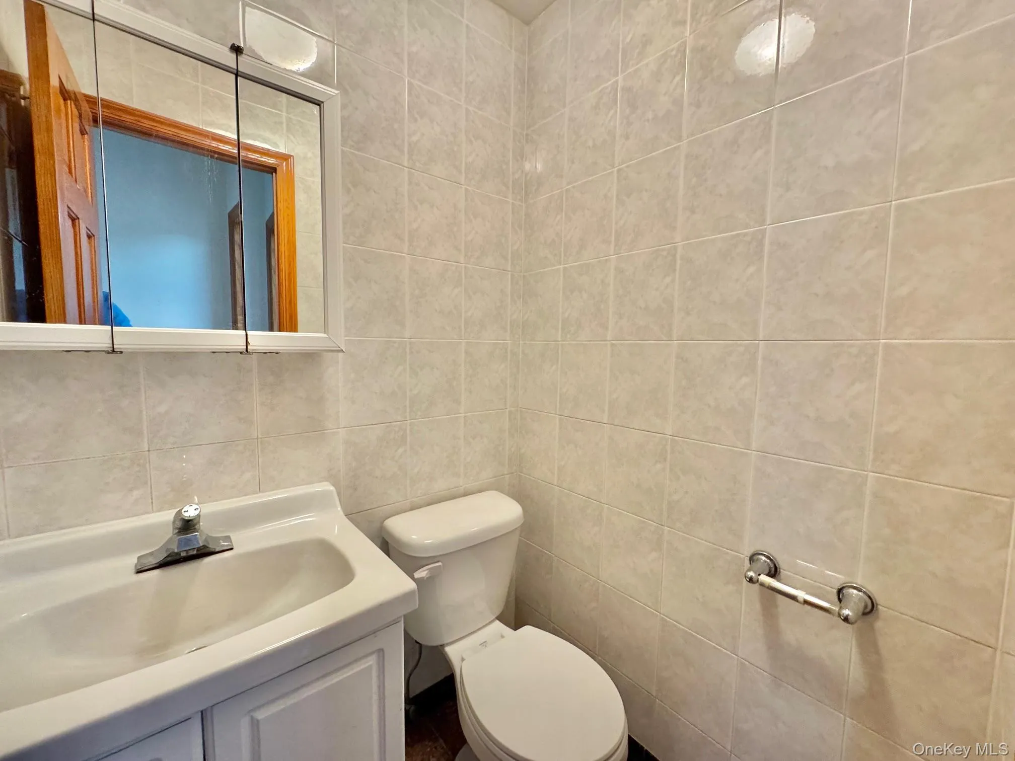 Half bathroom with tile walls and vanity Half bathroom with tile walls and vanity