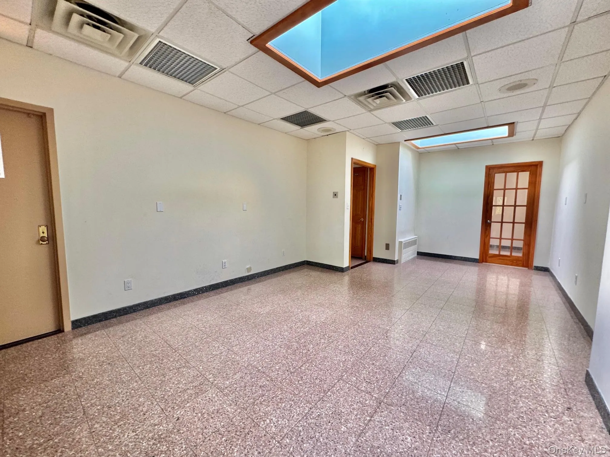 Empty room with a drop ceiling and granite floors Empty room with a drop ceiling and granite floors