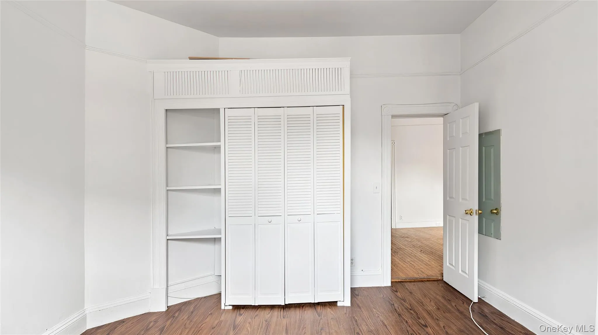 Unfurnished bedroom with dark wood-style flooring and a closet Unfurnished bedroom with dark wood-style flooring and a closet
