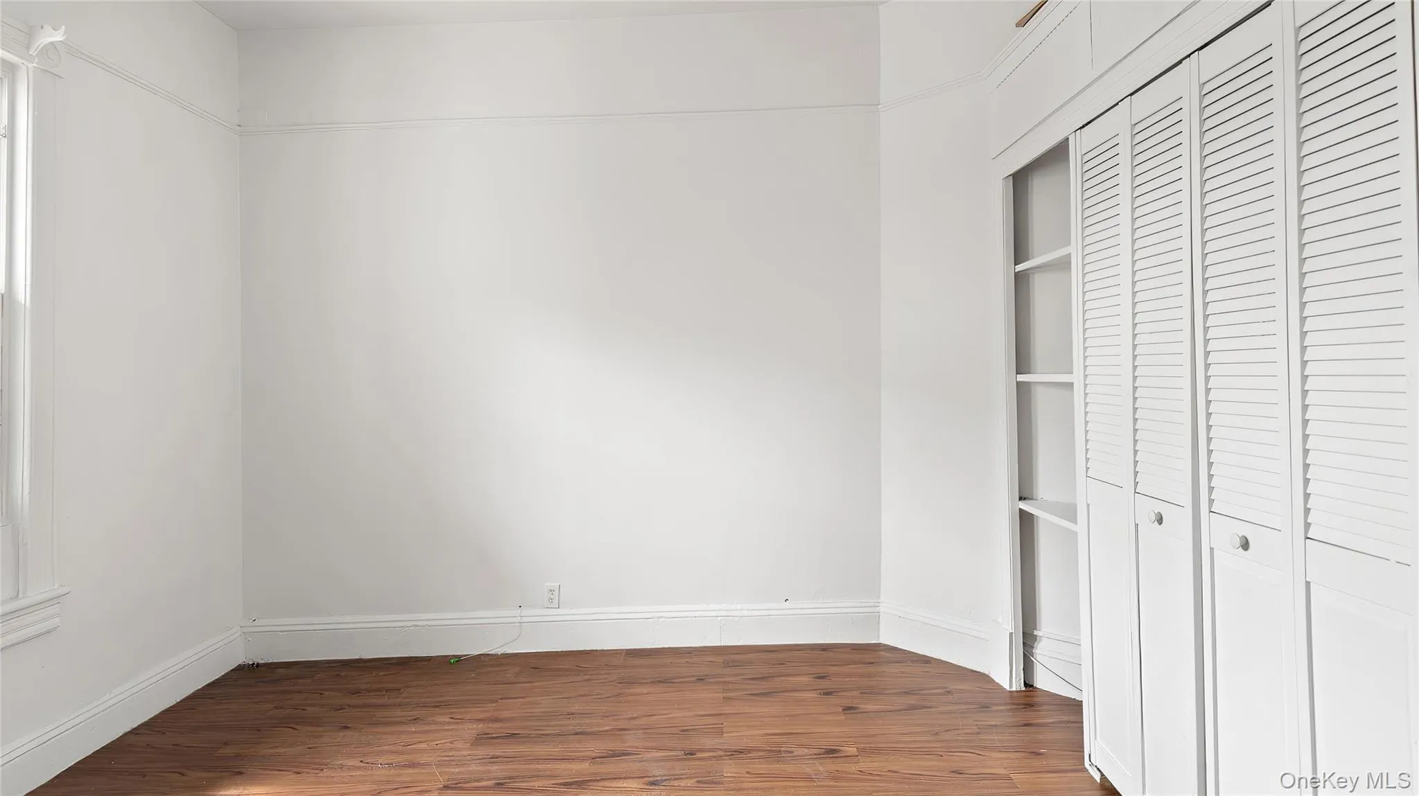 Unfurnished bedroom featuring a closet and dark wood-type flooring Unfurnished bedroom featuring a closet and dark wood-type flooring
