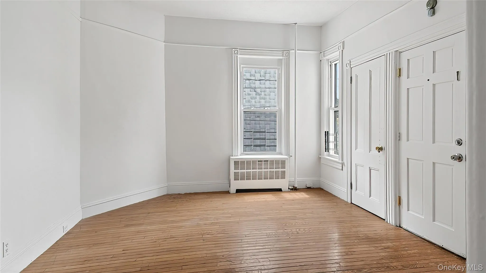 Unfurnished bedroom with light wood-type flooring and radiator Unfurnished bedroom with light wood-type flooring and radiator