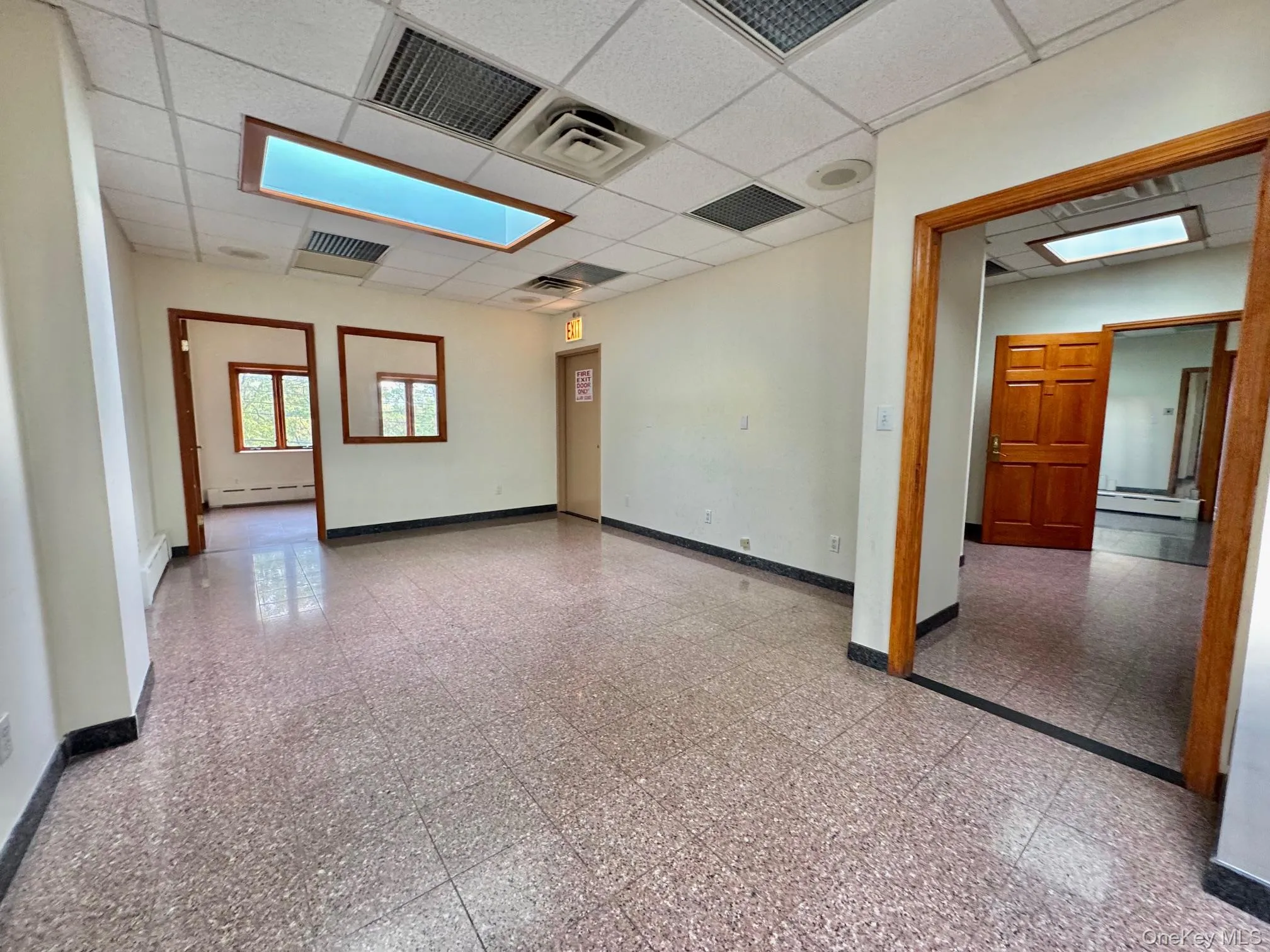 Empty room with a drop ceiling, a baseboard heating unit, and baseboard heating Empty room with a drop ceiling, a baseboard heating unit, and baseboard heating