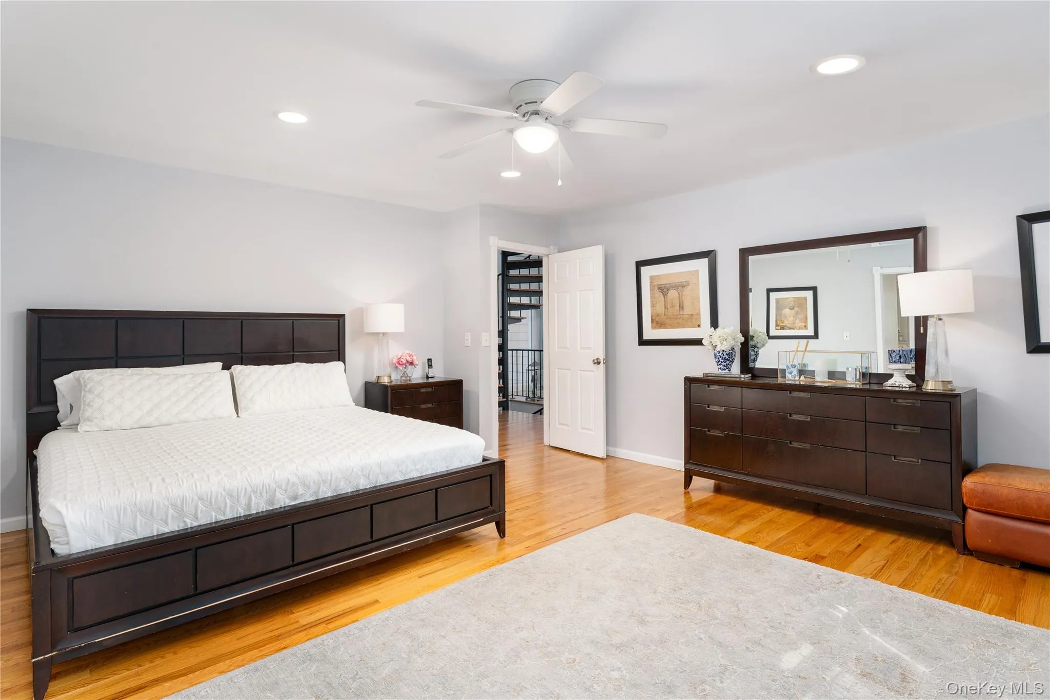 Bedroom with recessed lighting, light wood finished floors, and a ceiling fan Bedroom with recessed lighting, light wood finished floors, and a ceiling fan