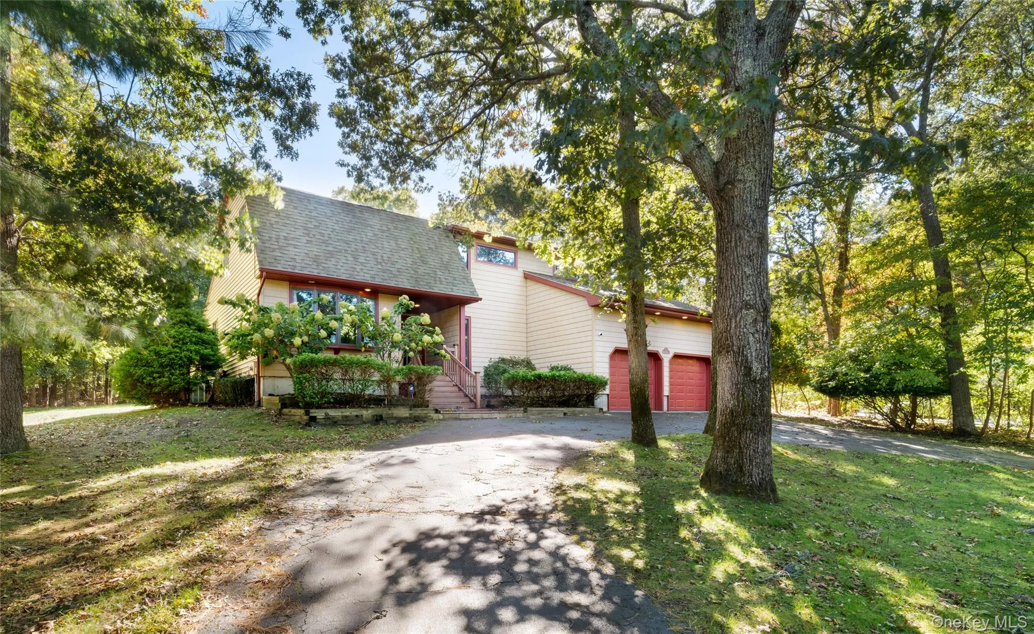 View of front of home with a shingled roof, a front yard, and driveway View of front of home with a shingled roof, a front yard, and driveway