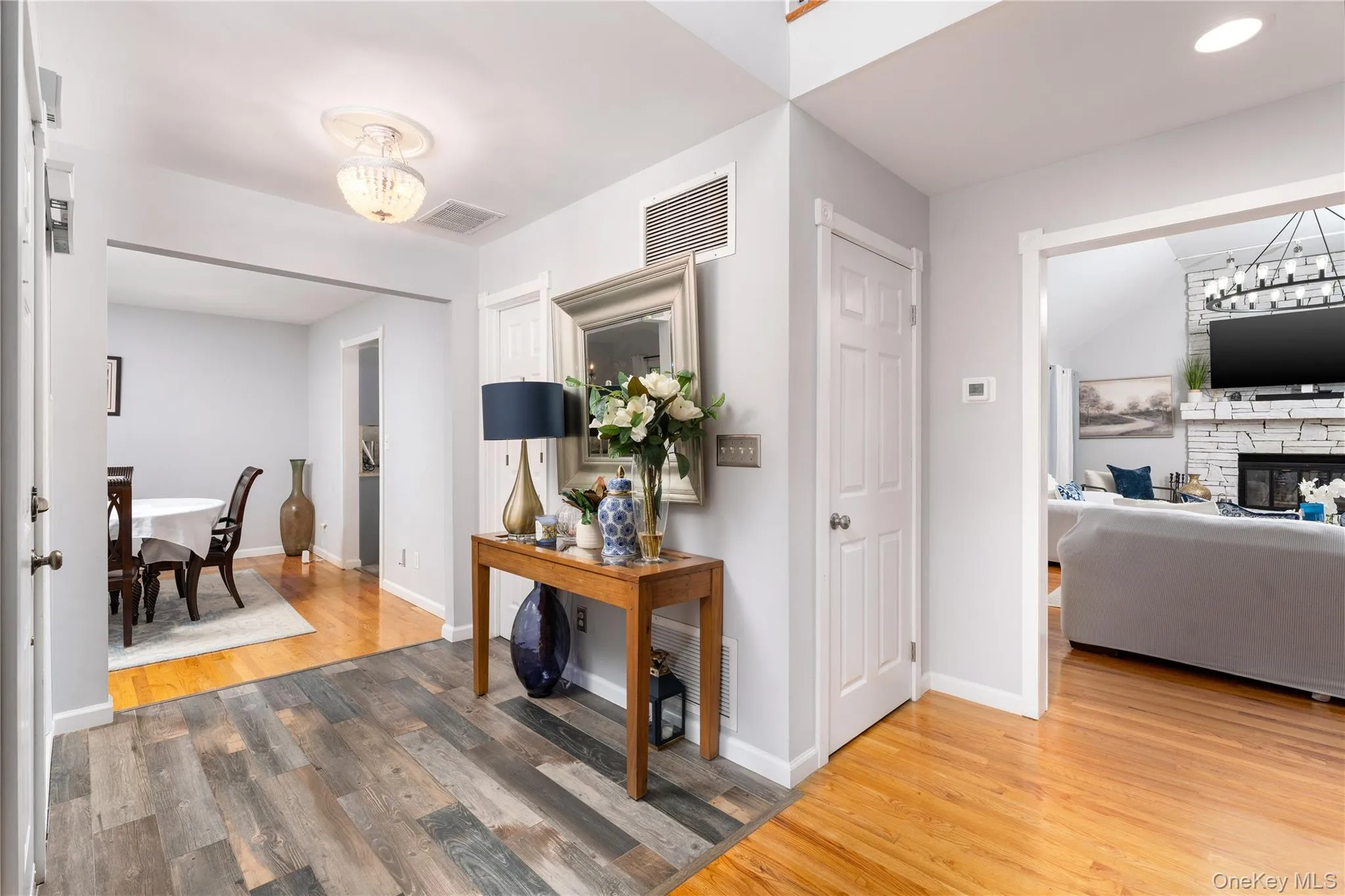 Hallway with a chandelier and light wood-style flooring Hallway with a chandelier and light wood-style flooring
