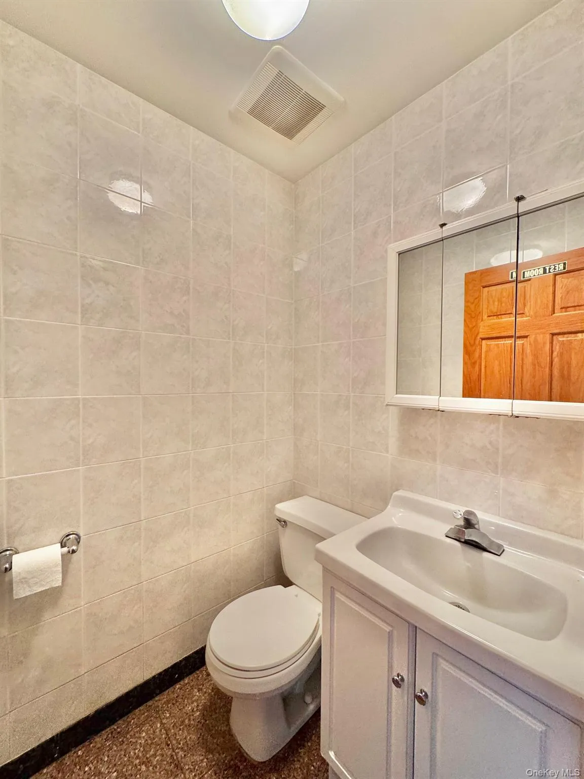 Half bathroom featuring tile walls and vanity Half bathroom featuring tile walls and vanity