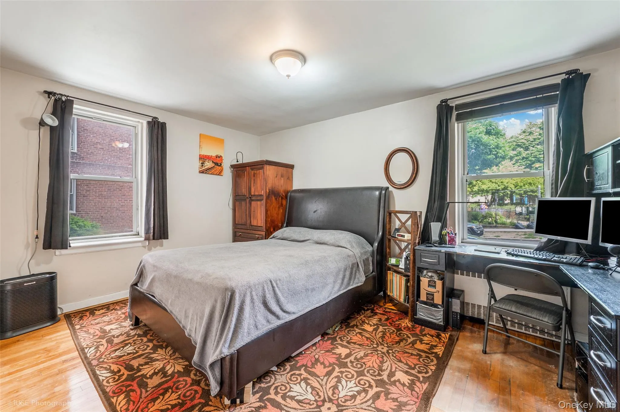 Bedroom with light wood-style flooring and an office area Bedroom with light wood-style flooring and an office area