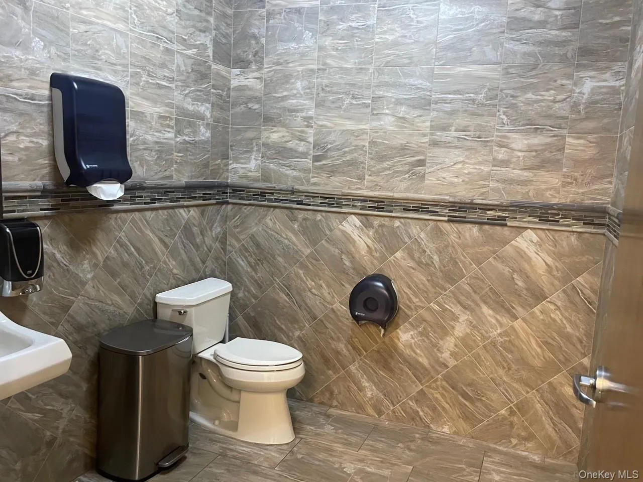Bathroom featuring tile walls and toilet Bathroom featuring tile walls and toilet