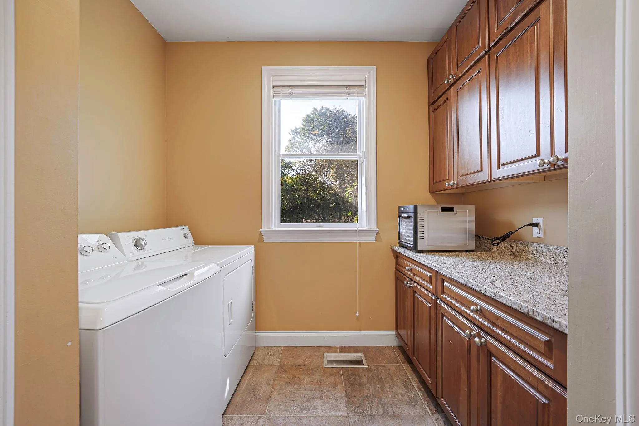 Washroom featuring cabinet space and washing machine and clothes dryer Washroom featuring cabinet space and washing machine and clothes dryer