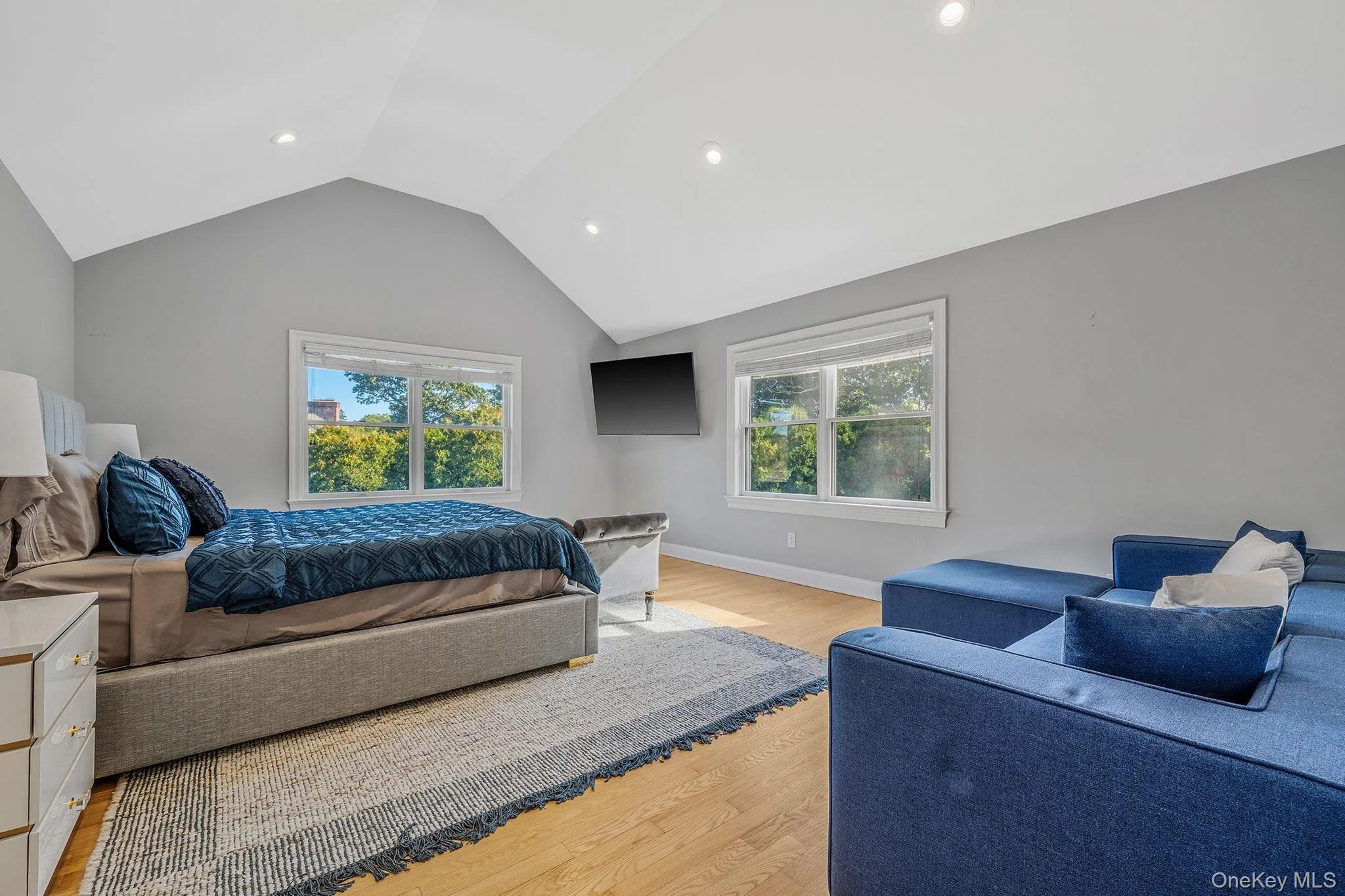 Bedroom featuring multiple windows, light wood finished floors, recessed lighting, and high vaulted ceiling Bedroom featuring multiple windows, light wood finished floors, recessed lighting, and high vaulted ceiling
