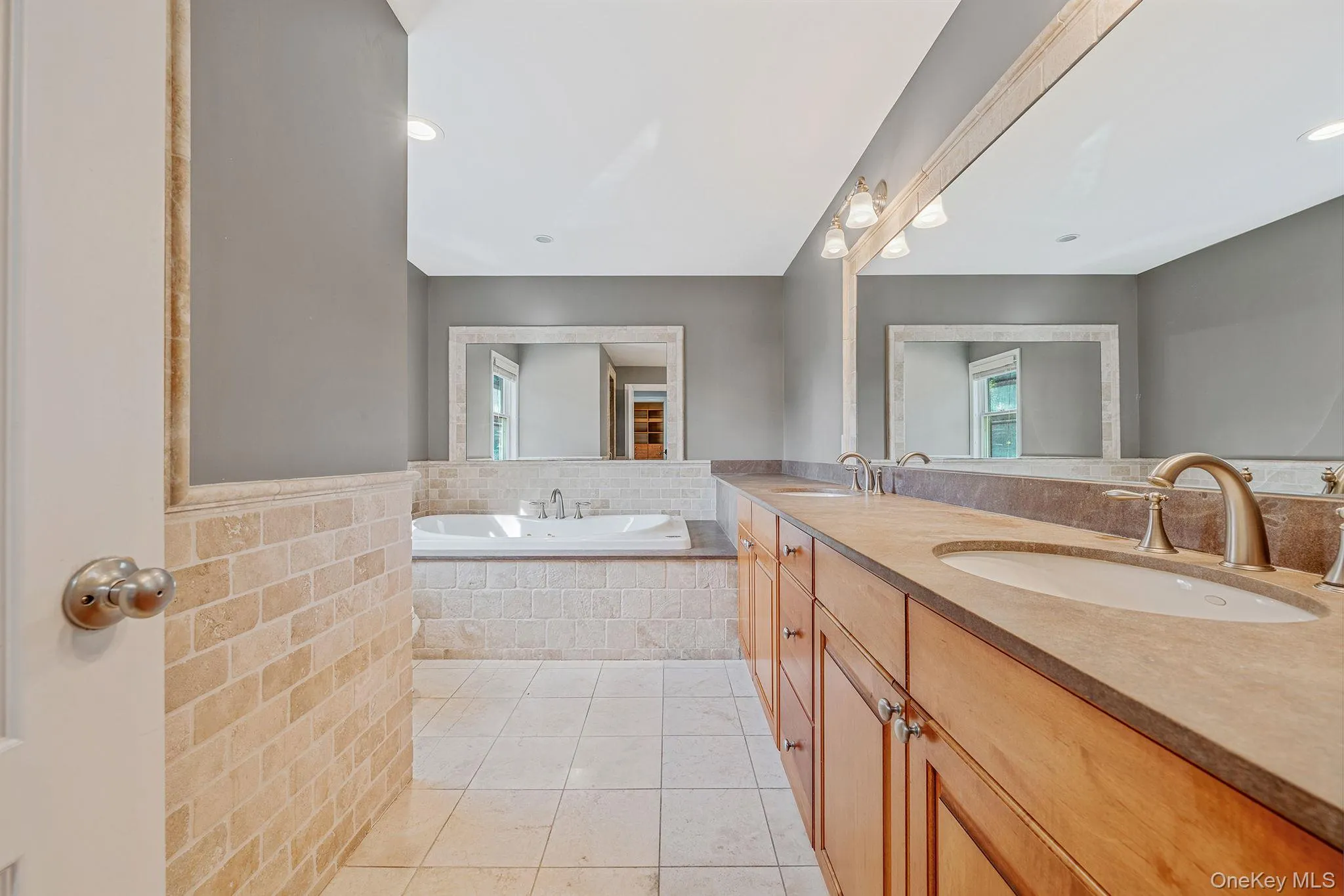 Full bath featuring light tile patterned floors, a bath, double vanity, and recessed lighting Full bath featuring light tile patterned floors, a bath, double vanity, and recessed lighting