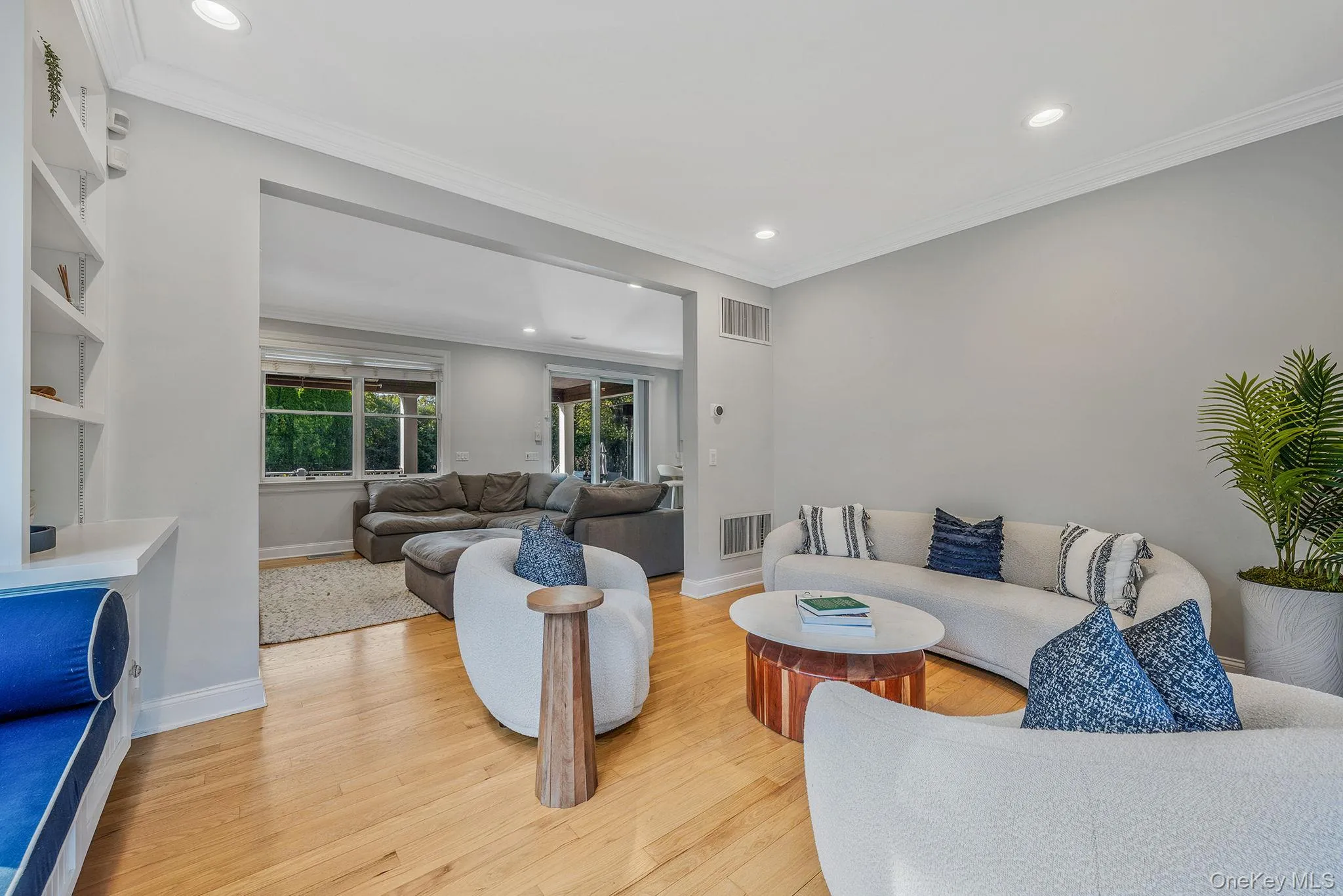 Living room featuring recessed lighting, ornamental molding, and light wood-type flooring Living room featuring recessed lighting, ornamental molding, and light wood-type flooring