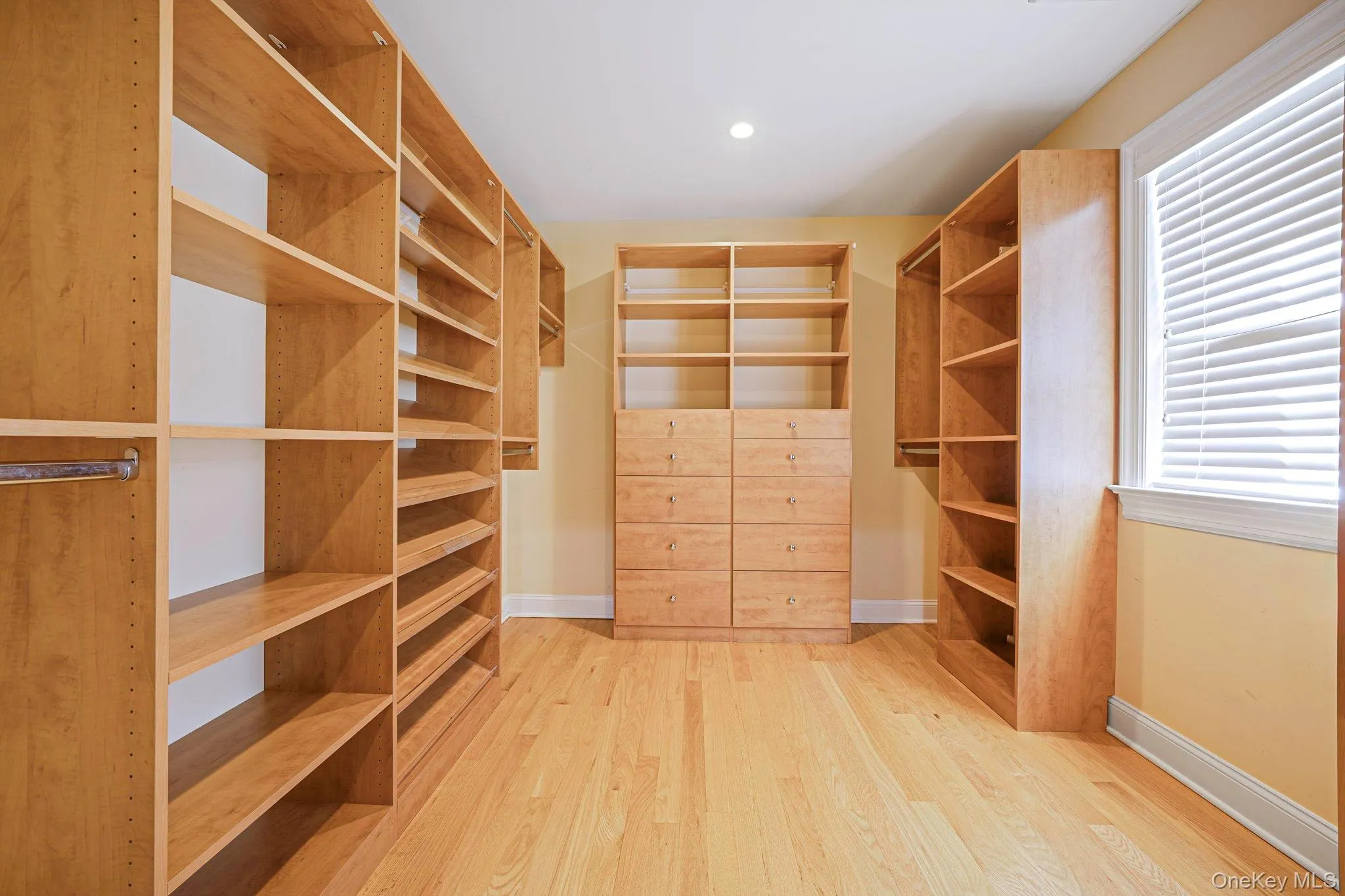 Spacious closet with light wood-style floors Spacious closet with light wood-style floors