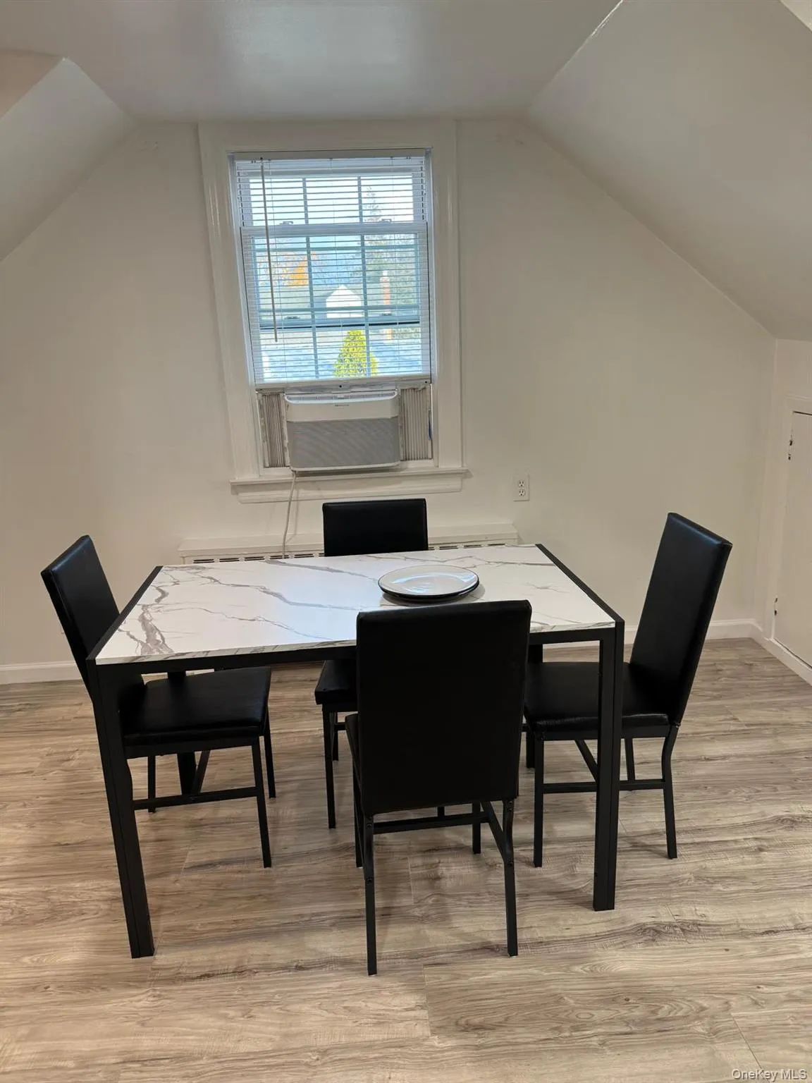 Dining area with vaulted ceiling, light wood-style floors, and cooling unit Dining area with vaulted ceiling, light wood-style floors, and cooling unit