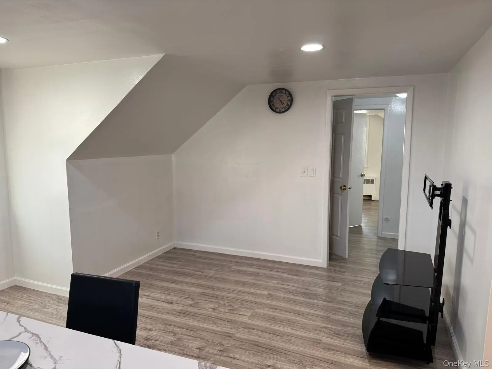 Bonus room with light wood-style flooring, recessed lighting, radiator heating unit, and vaulted ceiling Bonus room with light wood-style flooring, recessed lighting, radiator heating unit, and vaulted ceiling