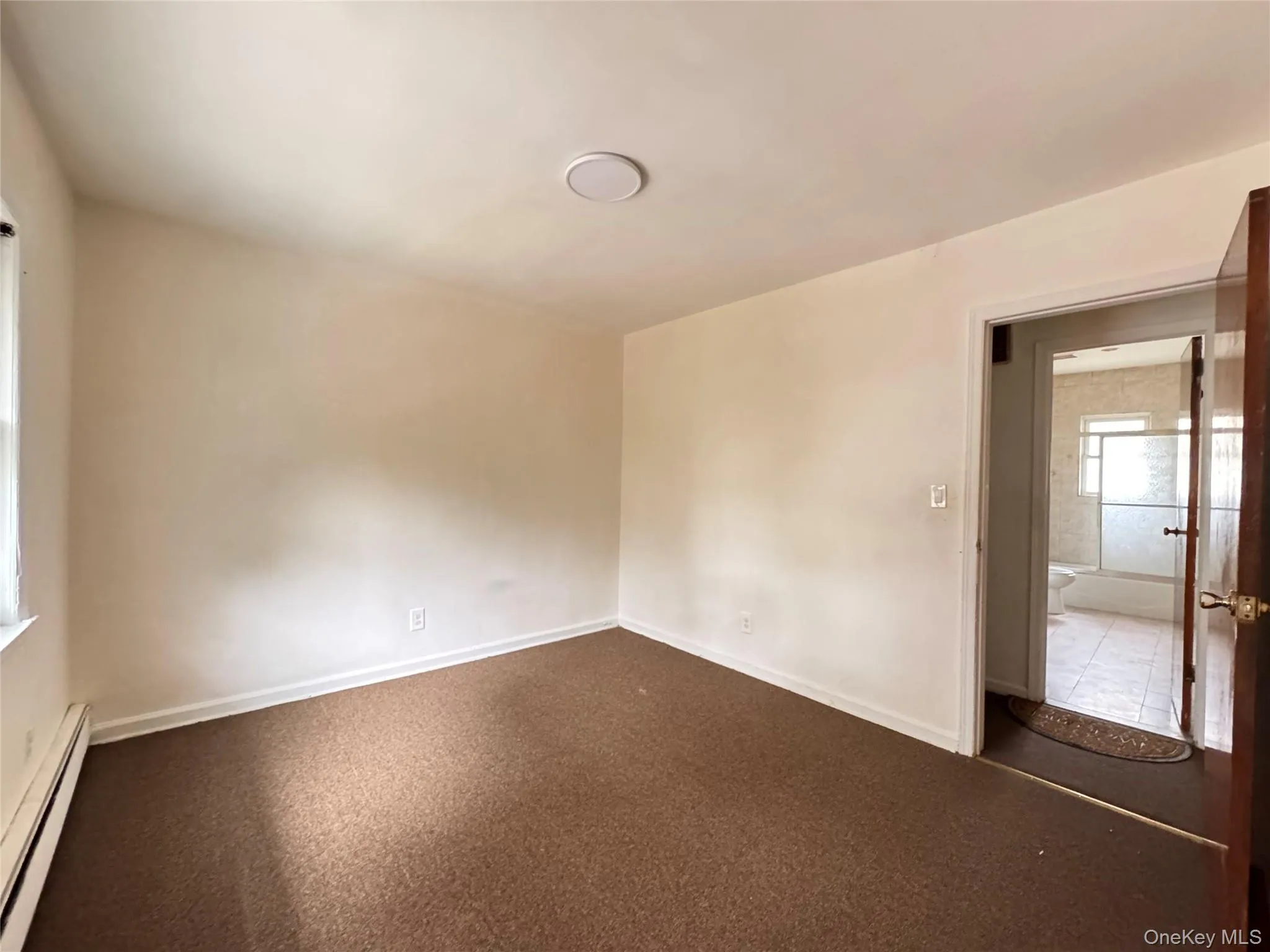 Empty room featuring a baseboard radiator and baseboards Empty room featuring a baseboard radiator and baseboards