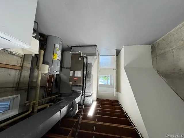 Below grade area with washer / clothes dryer, water heater, and heating unit Below grade area with washer / clothes dryer, water heater, and heating unit