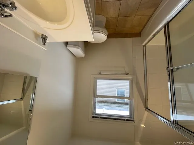 Bathroom with shower / bath combination with glass door, light tile patterned flooring, and vanity Bathroom with shower / bath combination with glass door, light tile patterned flooring, and vanity