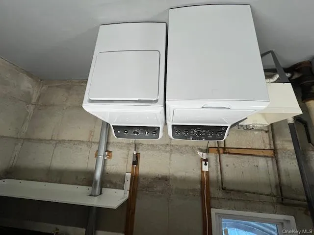 Laundry room featuring finished concrete floors and independent washer and dryer Laundry room featuring finished concrete floors and independent washer and dryer