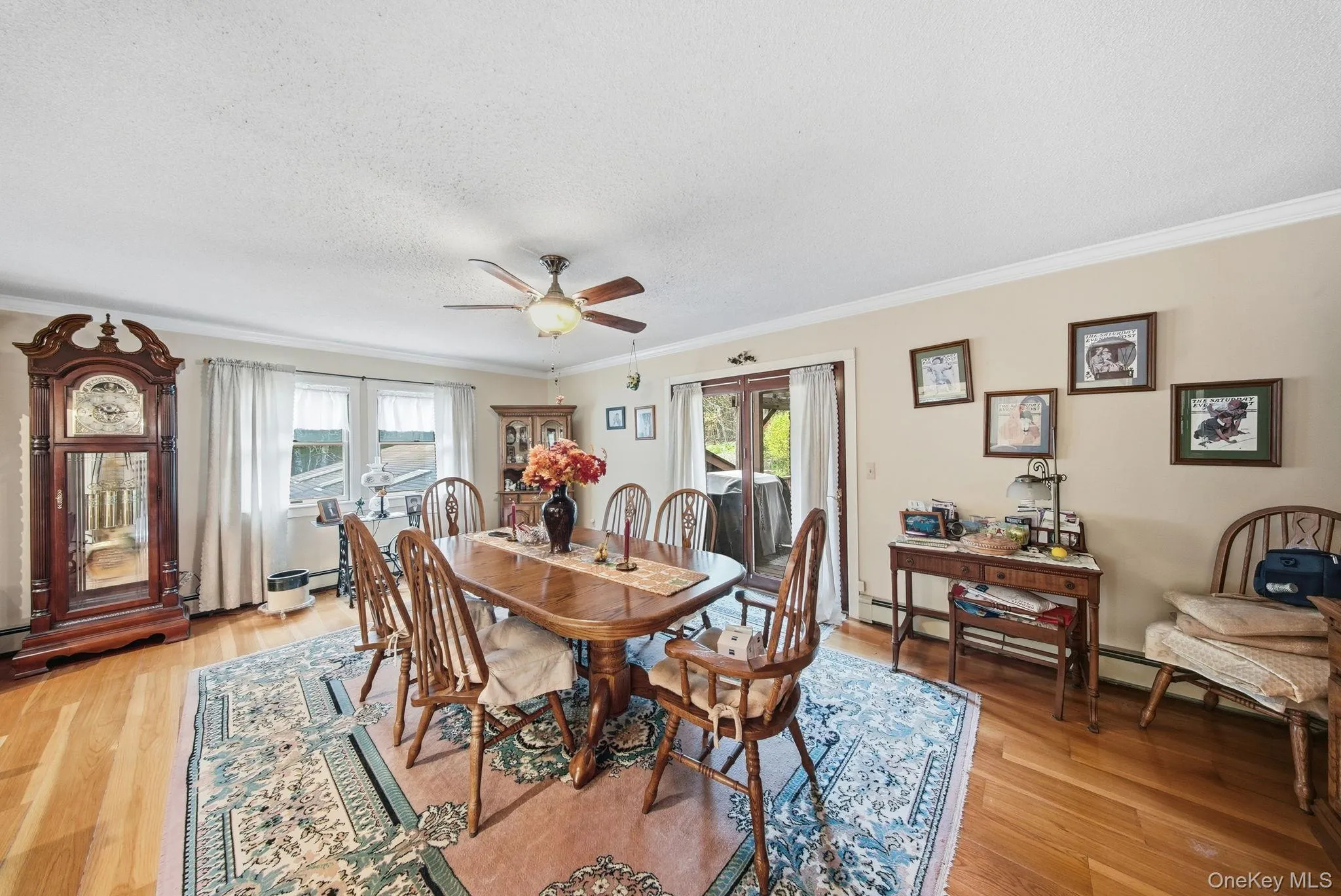 Dining space featuring ornamental molding, light wood-style flooring, a ceiling fan, french doors, and a textured ceiling Dining space featuring ornamental molding, light wood-style flooring, a ceiling fan, french doors, and a textured ceiling