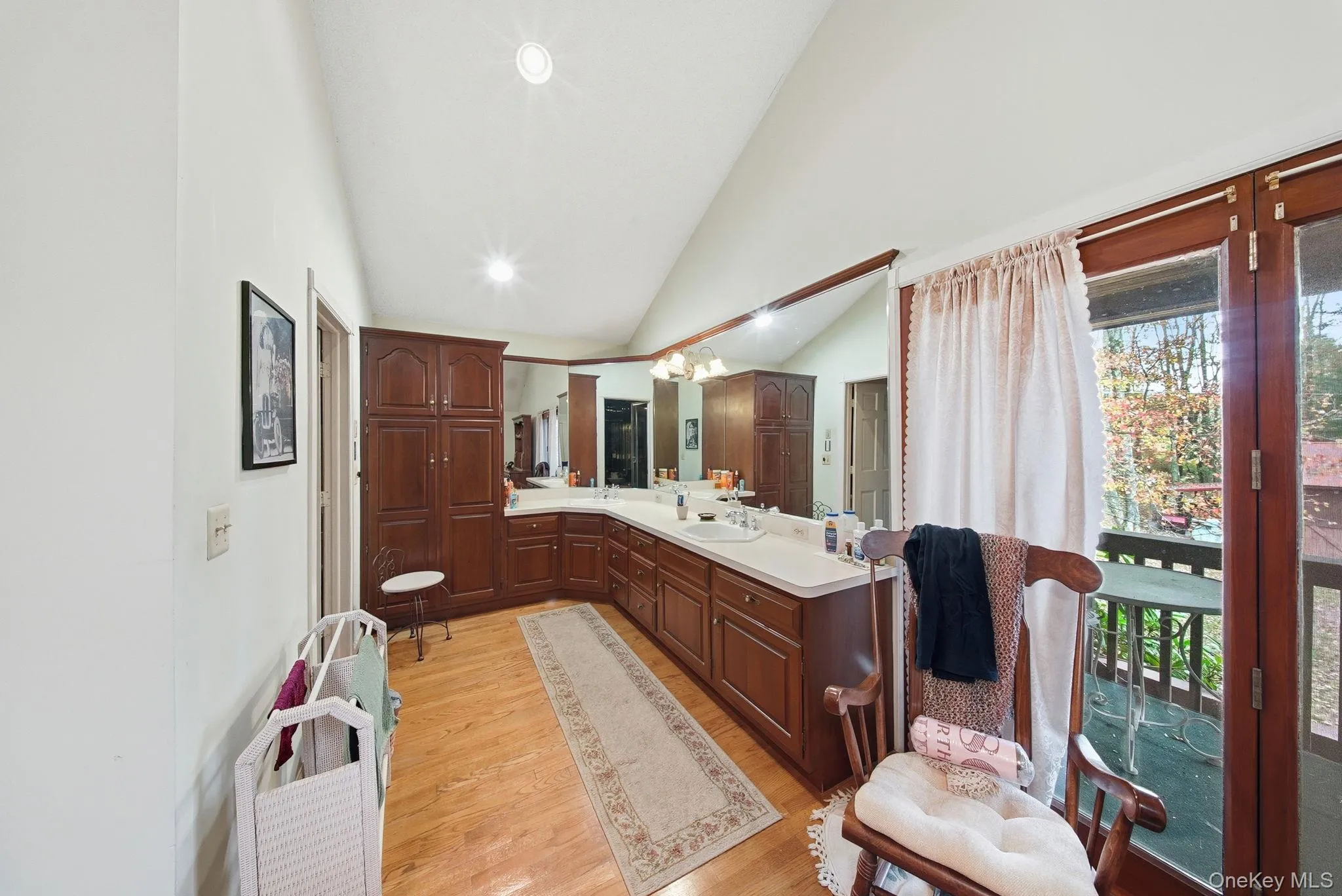 Bathroom with vanity, light wood finished floors, recessed lighting, high vaulted ceiling, and a chandelier Bathroom with vanity, light wood finished floors, recessed lighting, high vaulted ceiling, and a chandelier