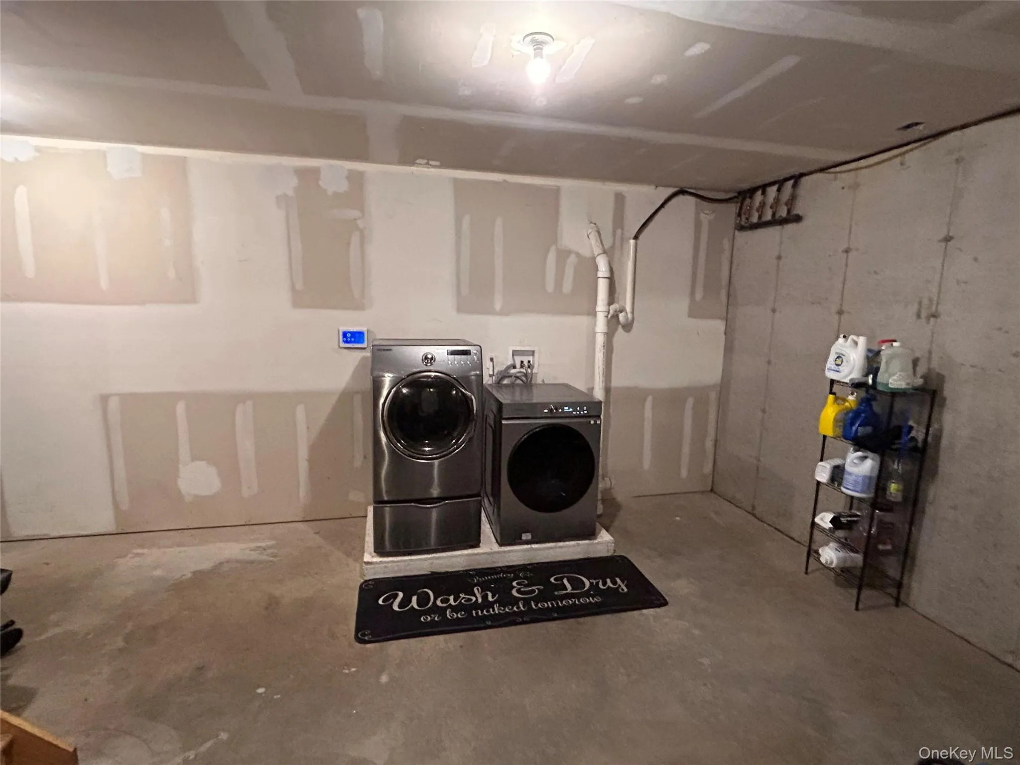 Laundry area with unfinished concrete floors and separate washer and dryer Laundry area with unfinished concrete floors and separate washer and dryer