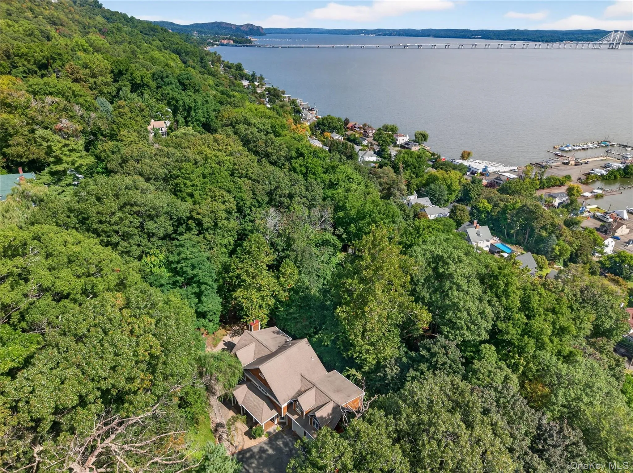 Aerial view of property's location featuring a nearby body of water and a forest Aerial view of property's location featuring a nearby body of water and a forest