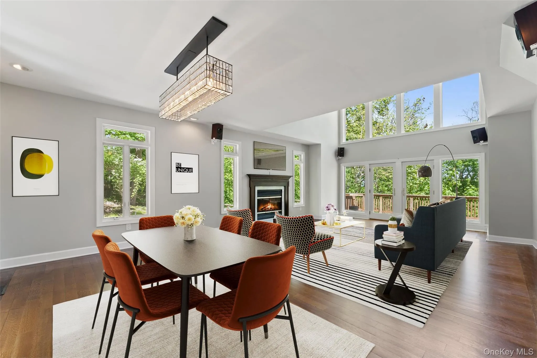 Dining room with a lit fireplace and wood finished floors Dining room with a lit fireplace and wood finished floors