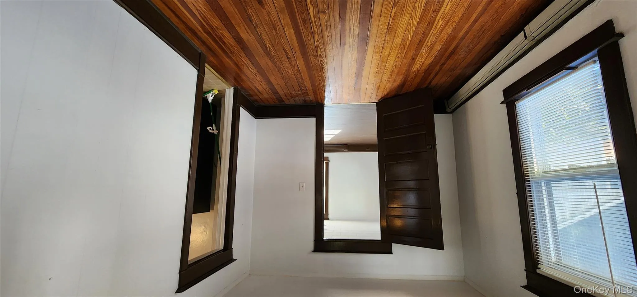 Unfurnished room with a baseboard heating unit and dark wood-style floors Unfurnished room with a baseboard heating unit and dark wood-style floors