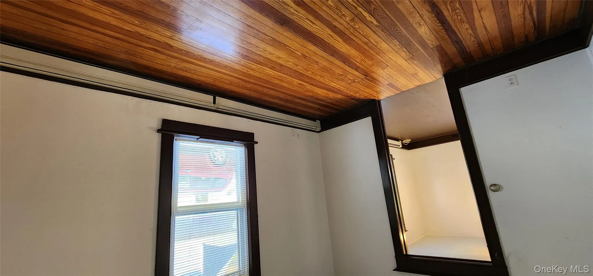 Spare room with baseboard heating and dark wood-style flooring Spare room with baseboard heating and dark wood-style flooring
