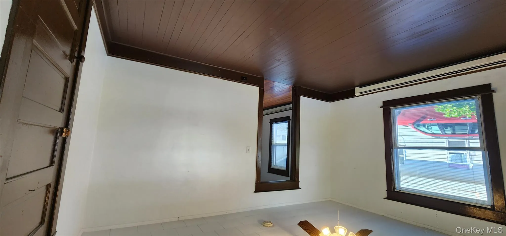 Spare room featuring baseboard heating, dark wood finished floors, ornamental molding, and ceiling fan Spare room featuring baseboard heating, dark wood finished floors, ornamental molding, and ceiling fan