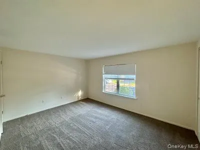 Spare room featuring dark carpet Spare room featuring dark carpet