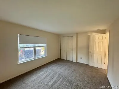 Unfurnished bedroom with carpet and a closet Unfurnished bedroom with carpet and a closet