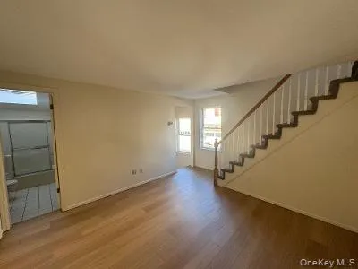 Unfurnished living room with stairs and wood finished floors Unfurnished living room with stairs and wood finished floors