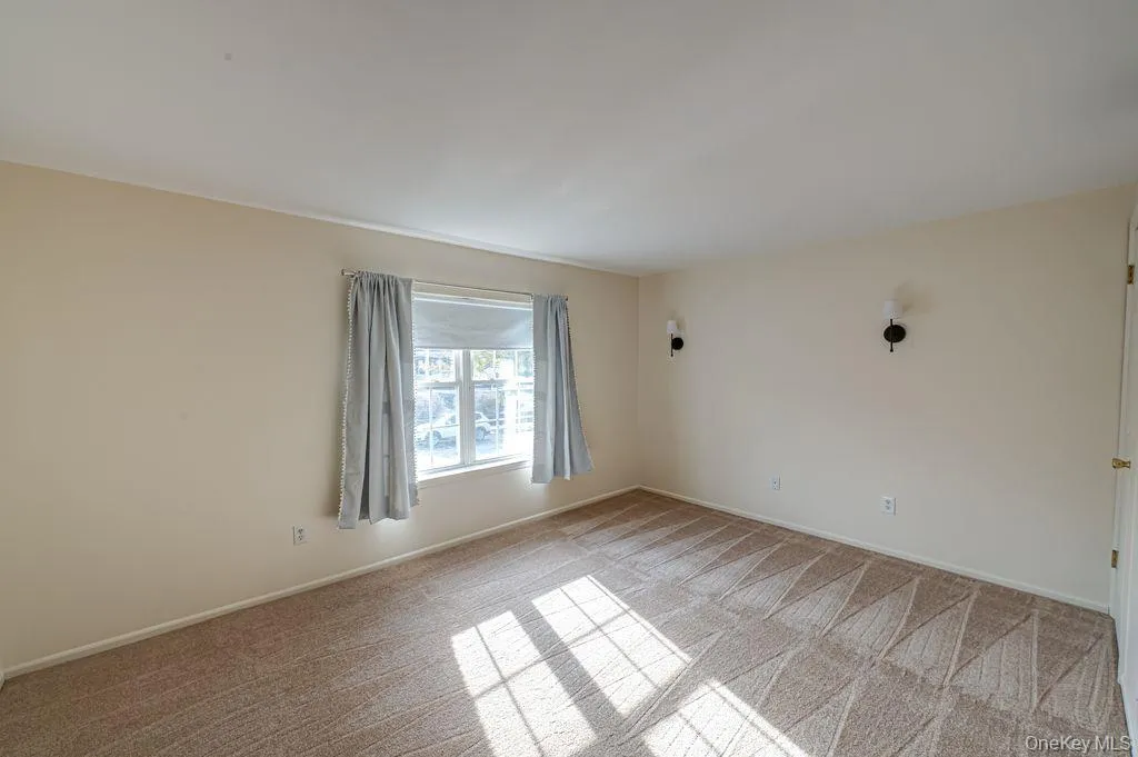 Unfurnished Sunlit Bedroom featuring new light carpet and baseboards Unfurnished Sunlit Bedroom featuring new light carpet and baseboards