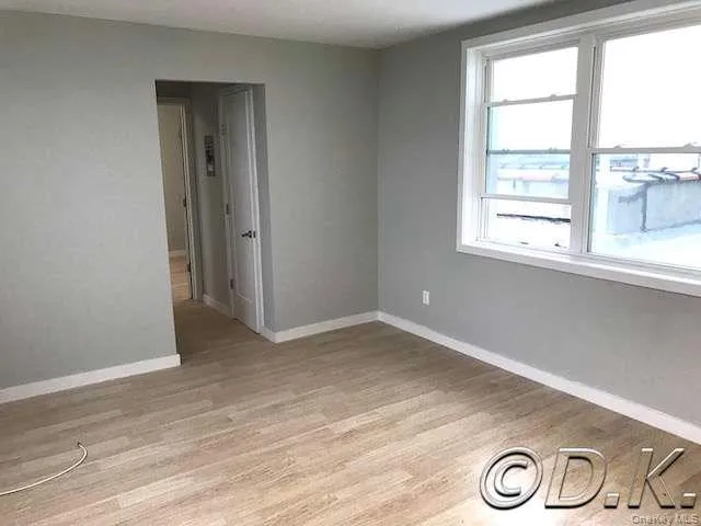 Spare room with light wood-style floors and baseboards Spare room with light wood-style floors and baseboards