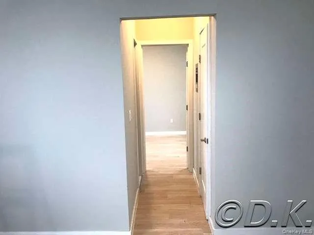 Hallway featuring light wood-style floors and baseboards Hallway featuring light wood-style floors and baseboards