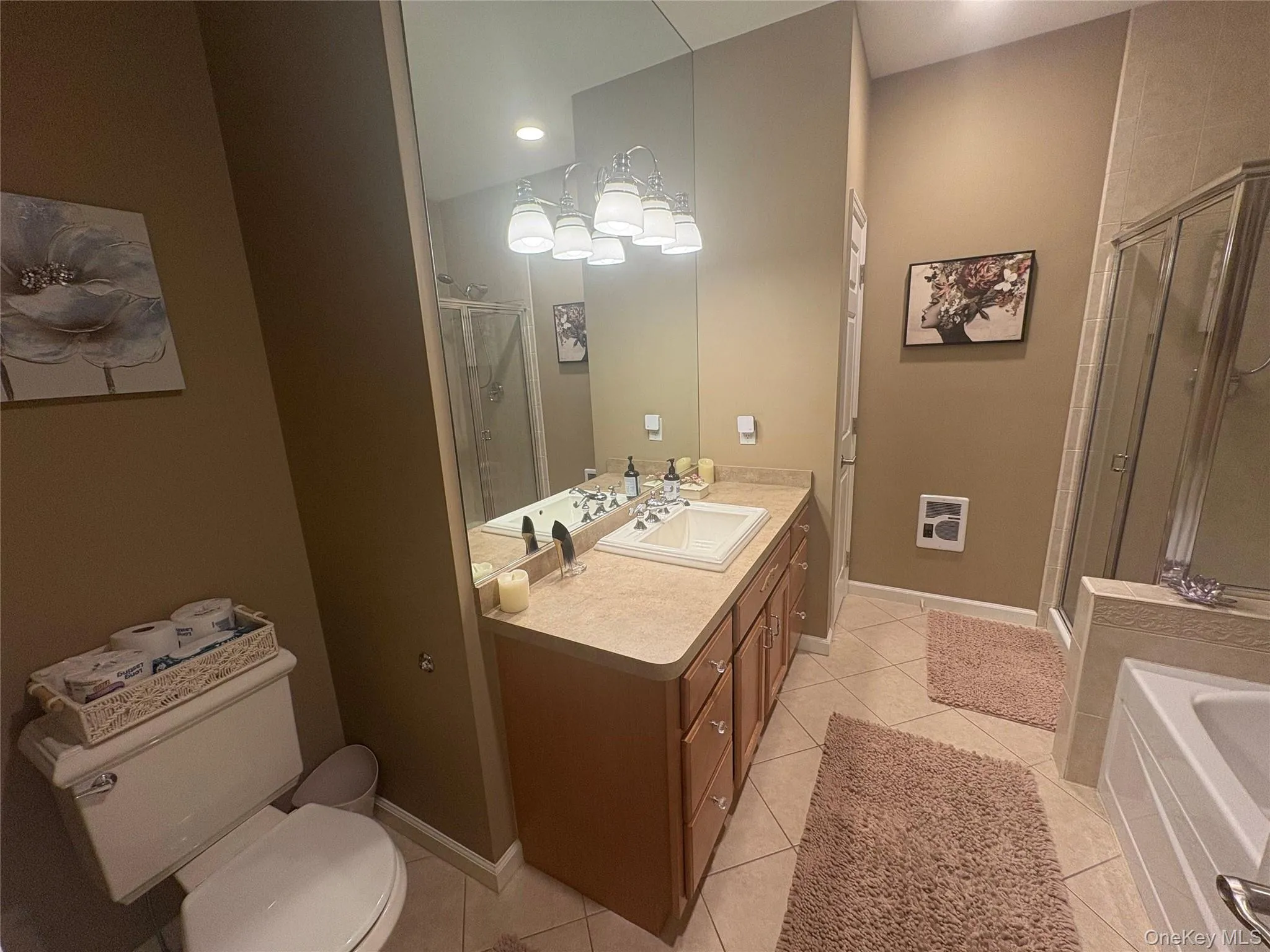 Bathroom featuring vanity, a stall shower, light tile patterned floors, and a bathtub Bathroom featuring vanity, a stall shower, light tile patterned floors, and a bathtub