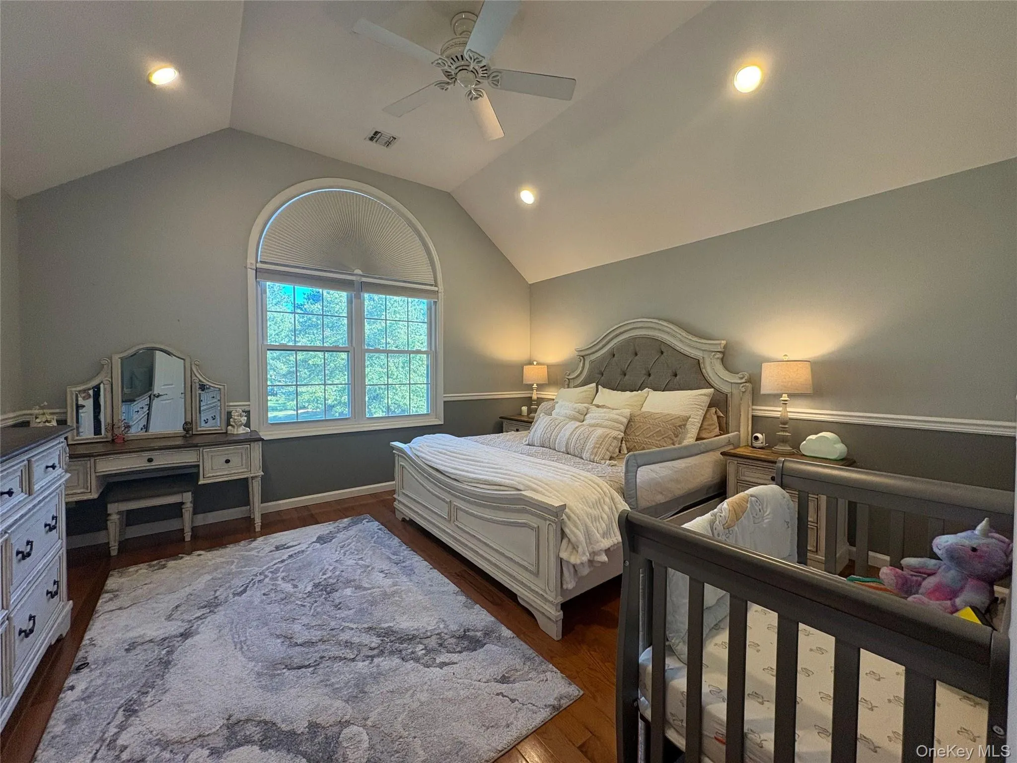 Bedroom with dark wood finished floors, vaulted ceiling, recessed lighting, and a ceiling fan Bedroom with dark wood finished floors, vaulted ceiling, recessed lighting, and a ceiling fan