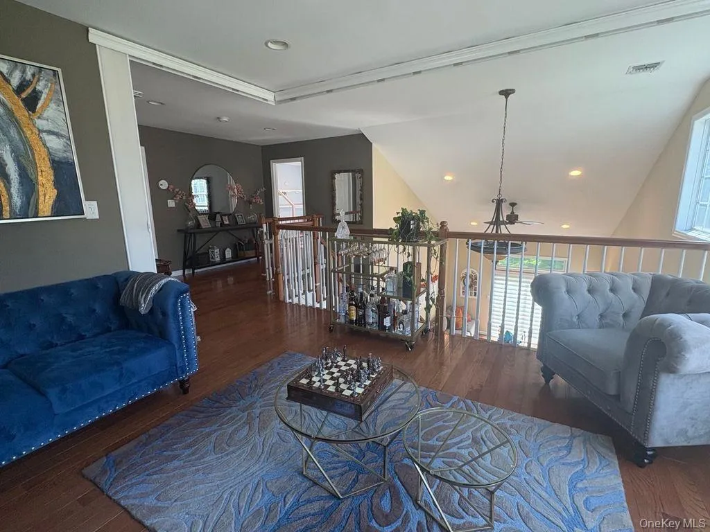 Loft with wood finished flooring recessed lighting, and lofted ceiling Loft with wood finished flooring recessed lighting, and lofted ceiling