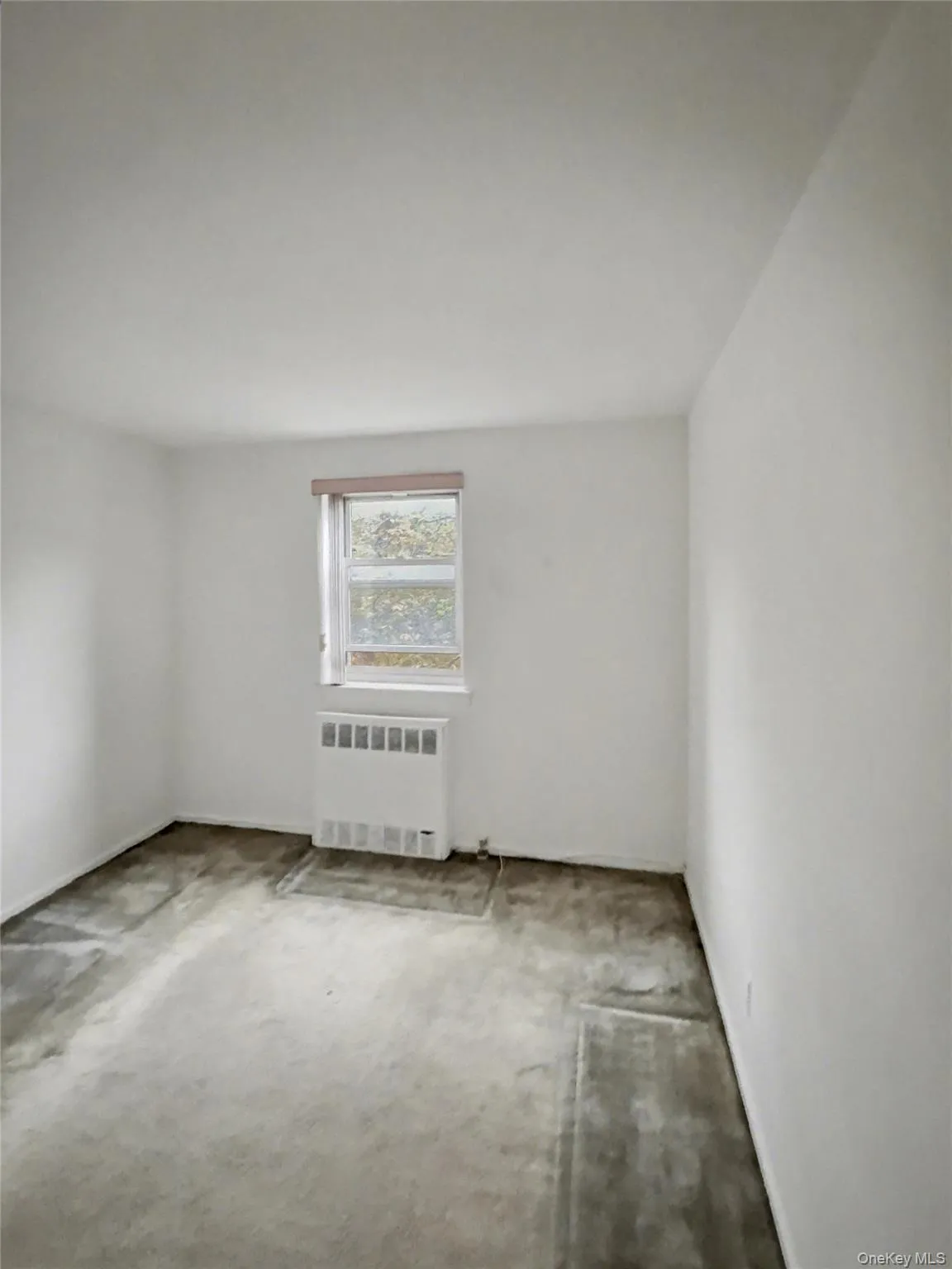 Spare room with radiator and carpet floors Spare room with radiator and carpet floors