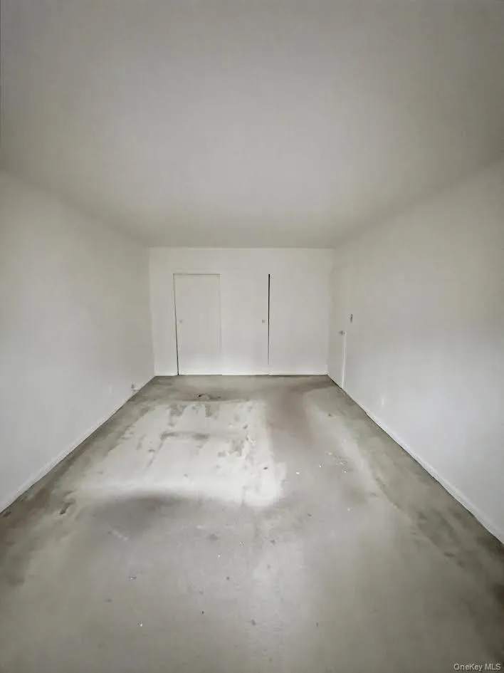 Empty room featuring concrete flooring and baseboards Empty room featuring concrete flooring and baseboards