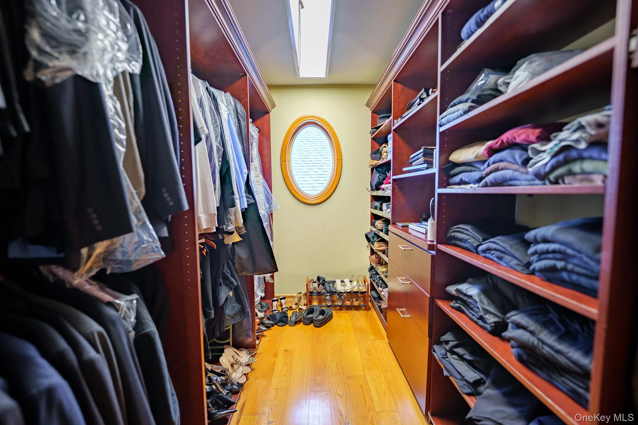 Spacious closet with light wood-style floors Spacious closet with light wood-style floors