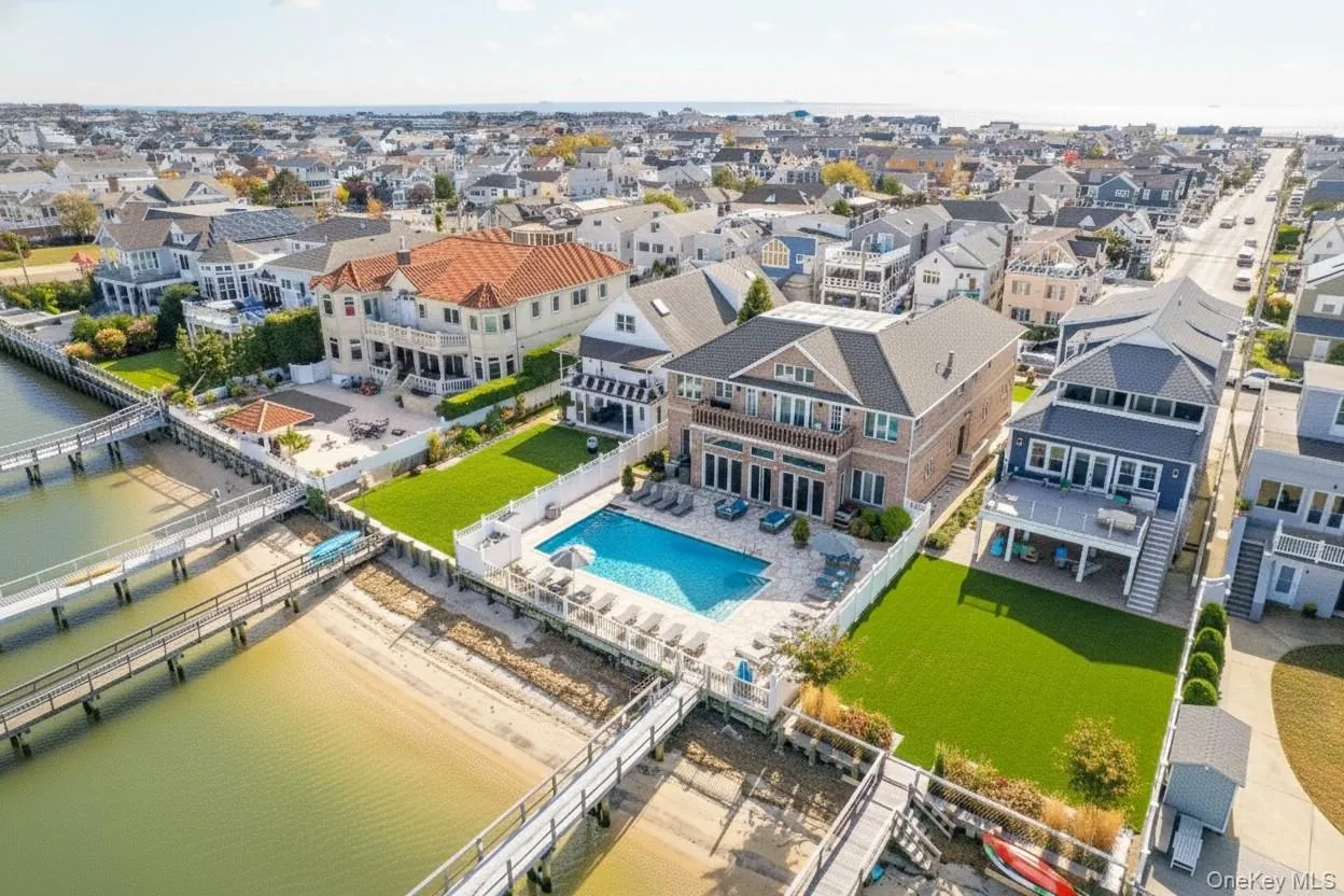 Aerial view of residential area with a pool area and a nearby body of water Aerial view of residential area with a pool area and a nearby body of water