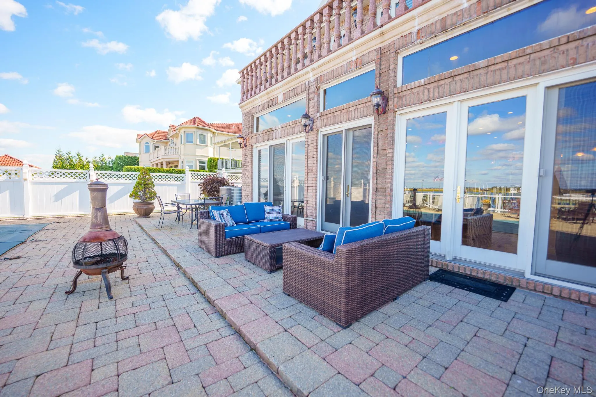 Fenced backyard with a patio area, an outdoor living space with a fire pit, and outdoor dining space Fenced backyard with a patio area, an outdoor living space with a fire pit, and outdoor dining space