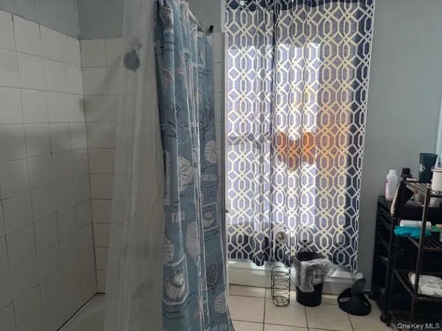 Bathroom with shower / tub combo and light tile patterned floors Bathroom with shower / tub combo and light tile patterned floors
